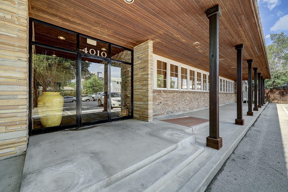 Covered front walkway with timber ceiling and stone columns